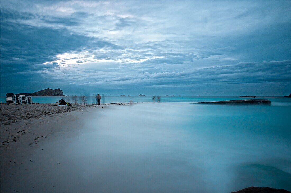 People in cala Compte beach at dusk, Ibiza, Balearic Islands, Spain