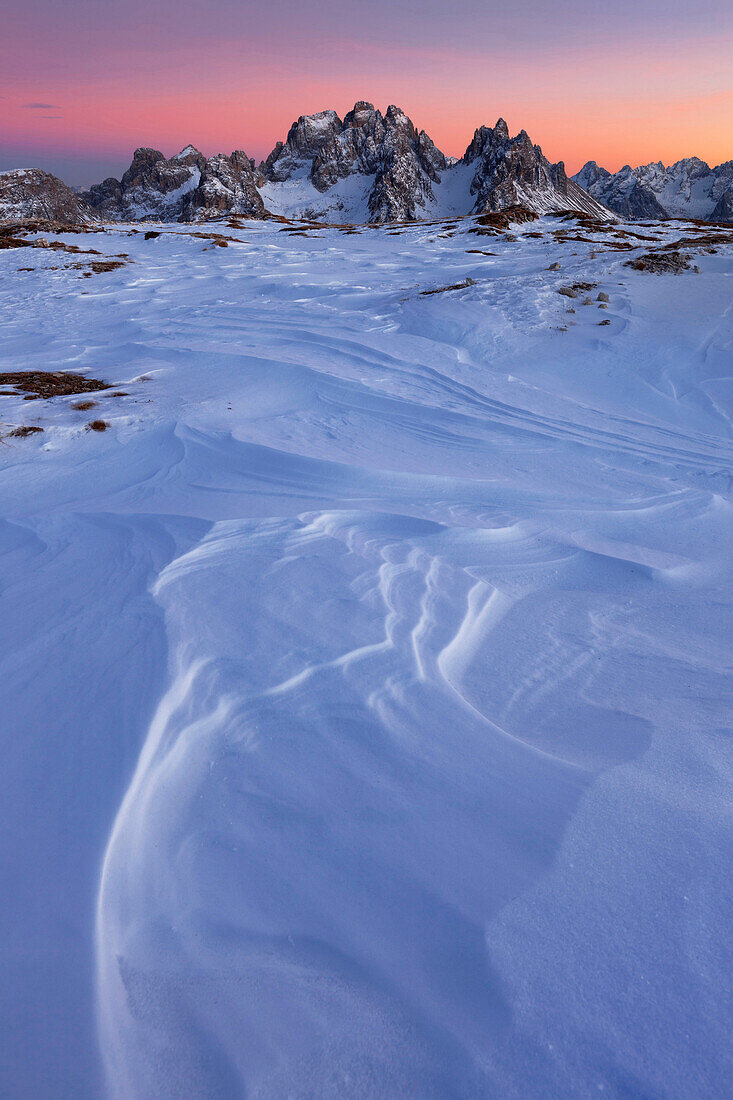 Sonnenuntergang mit Schneestrukturen auf dem Hochplateau des Monte Piano mit Blick nach Süden auf die Cadini-Gruppe, Sextener Dolomiten, Südtirol, Italien