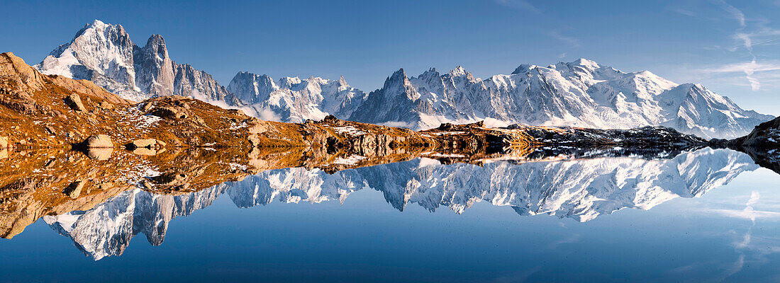 Panorama einer perfekten Spiegelung des Mont Blanc Massivs im Bergsee Lac de Chésery mit Auigelle Verte und Grande Jurasse im Herbst, Chamonix Tal, Haute-Savoie, Frankreich