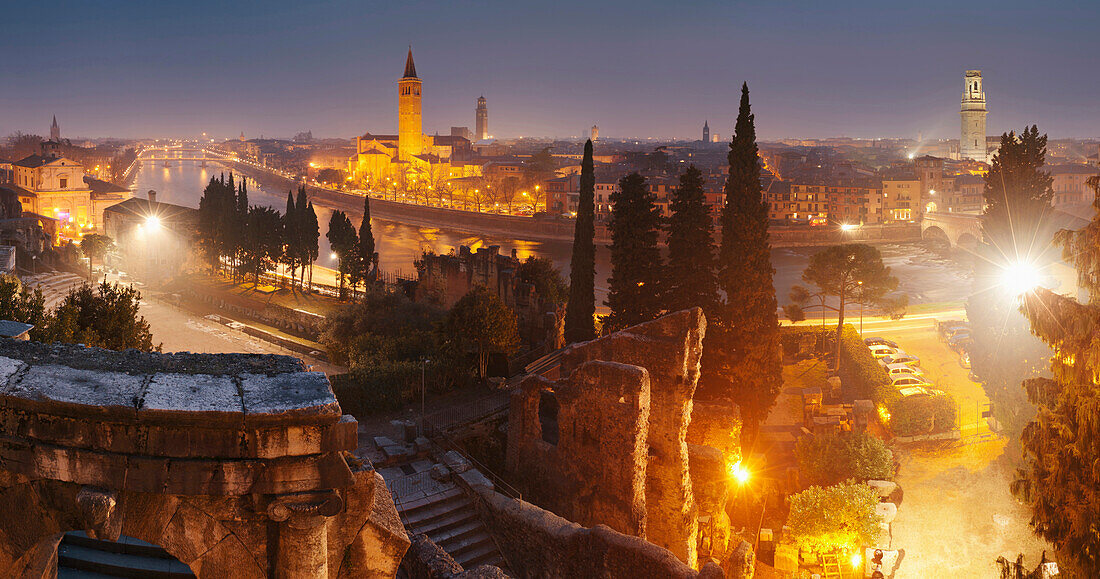 View of Verona and the river Etsch from the Teatro Romano at night with the church towers of Sant’ Anastasia and of Verona’s cathedral, Veneto, Italy