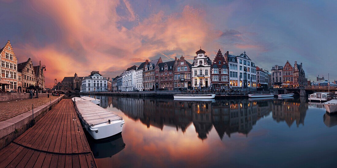 A colorful sunset over the canals of the old city of Ghent in Flanders with the historic gabled houses of Graselei (left) and Korenlei (right), Belgium