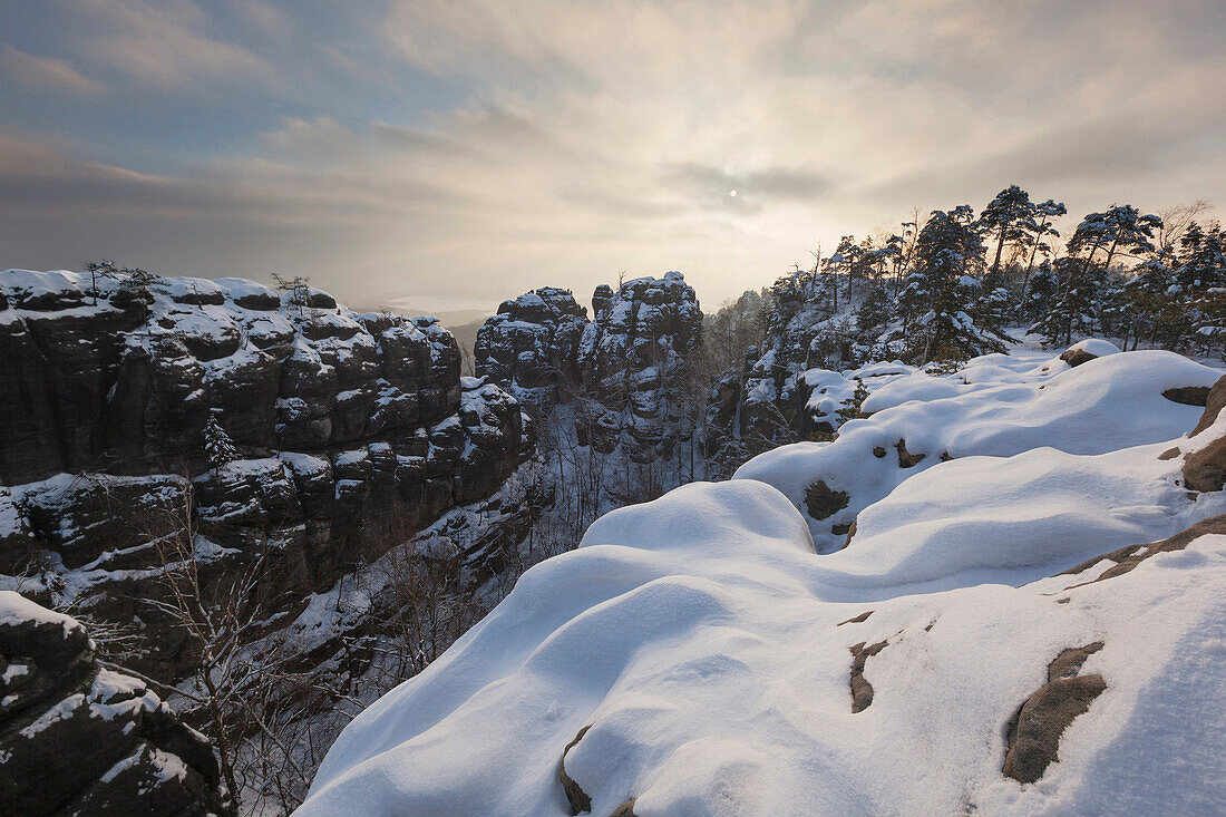 Fahles Licht über dem Nationalpark Sächsische Schweiz mit Blick auf die Wenzelwand und die Gerbingspitze im Winter, Sachsen, Deutschland