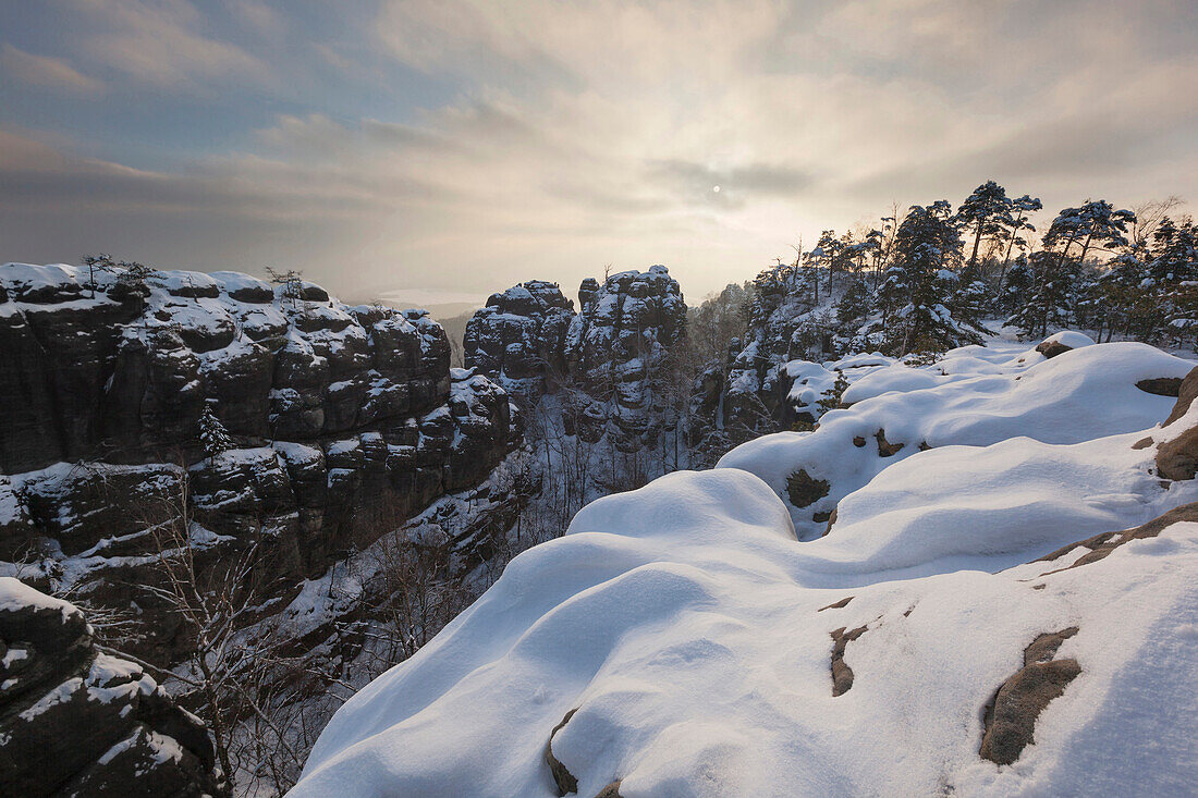 Shallow light above the Saxon Switzerland national park with a wide view to the Wenzelwand and the Gerbingspitze in winter, Saxony, Germany