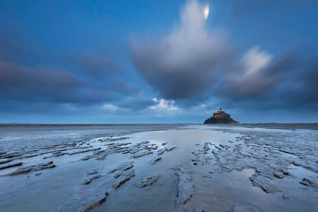 Langzeitbelichtung im Blau der Nacht mit Blick auf die weltberühmte Abtei aus dem 10ten Jahrhundert, Mont-Saint-Michel mit Watt im Vordergrund, Normandie, Frankreich