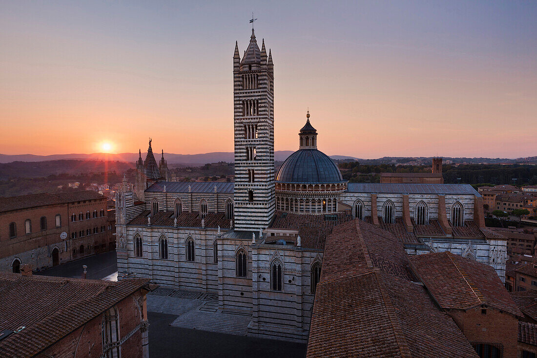 Sunset over the Cathedral of Siena Cattedrale di Santa Maria Assunta with its white and greenish-black marble, Siena, Tuscany, Italy