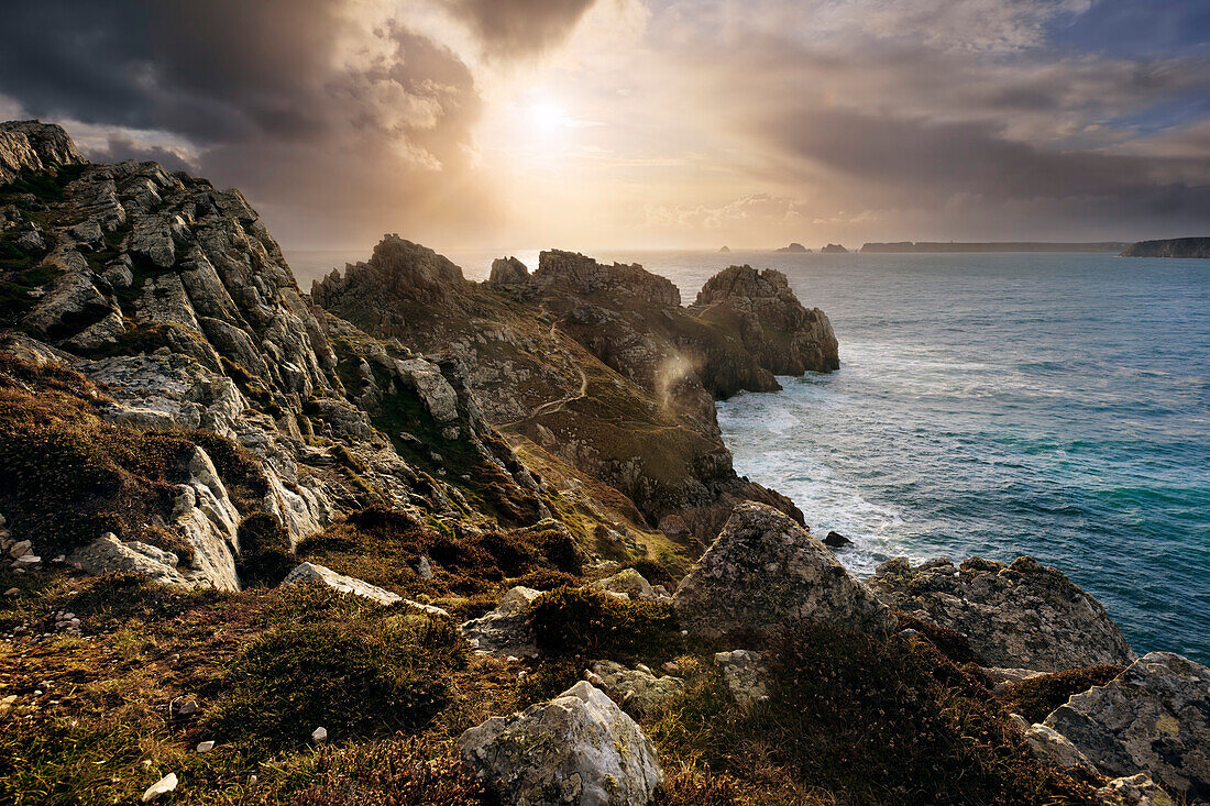 Breathtaking sunset light above the Crozon Peninsula on an unsettled day in spring with the Island Pointe de Penhir in the background, Brittany, France