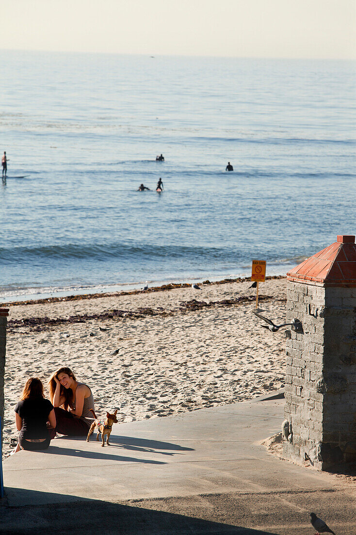 USA, California, Malibu, young women carry on a conversation at Surfrider Beach, the Malibu Pier