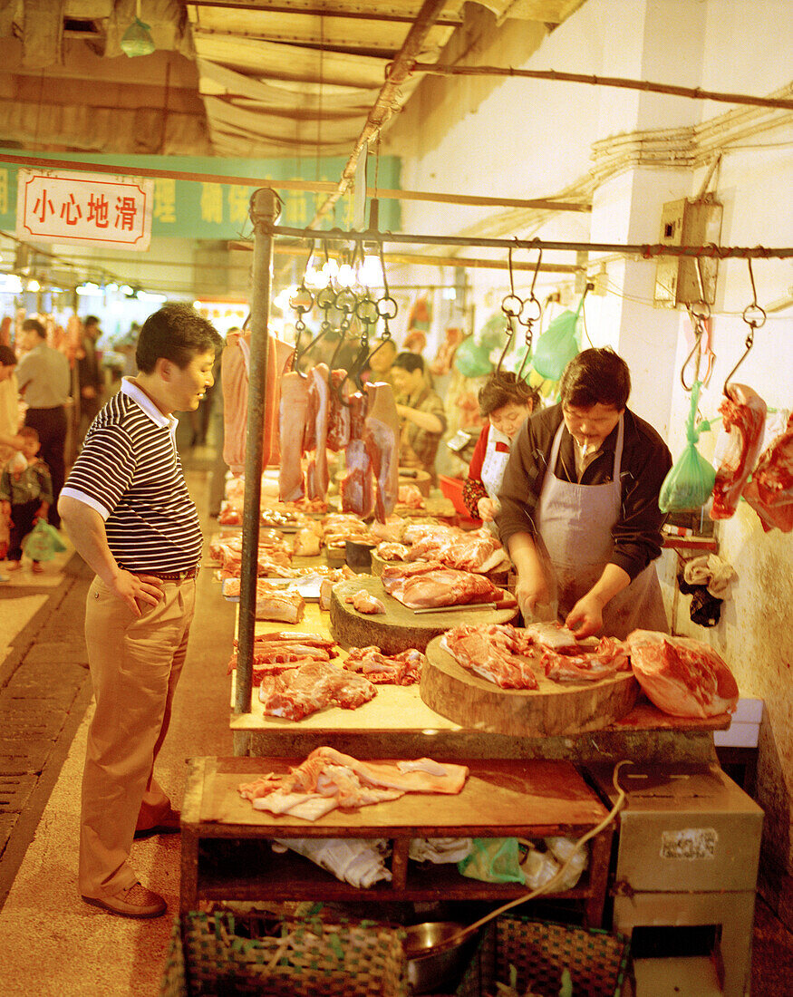 CHINA, Hangzhou, customer and butcher at local market