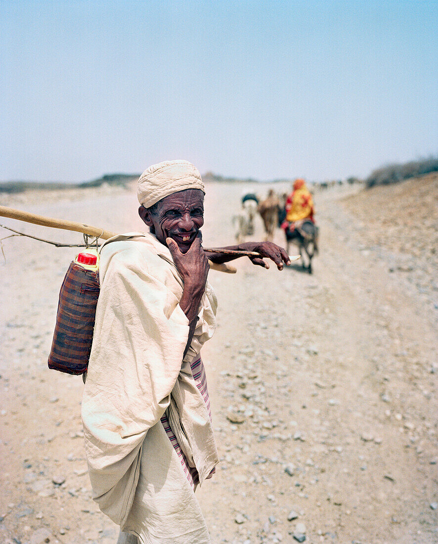 ERITREA, Foro, A Bedouin herder follows his livestock down a dirt road