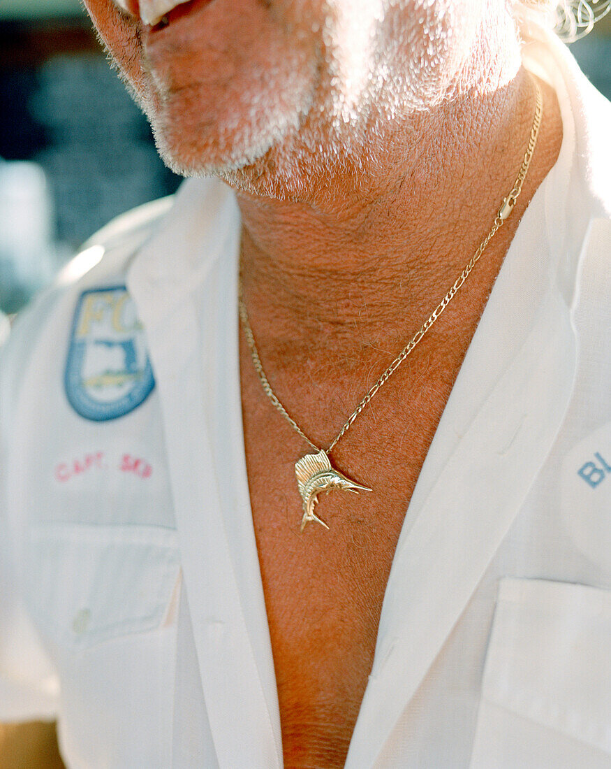 USA, Florida, fishing captain wearing marlin pendant, close-up, Islamorada