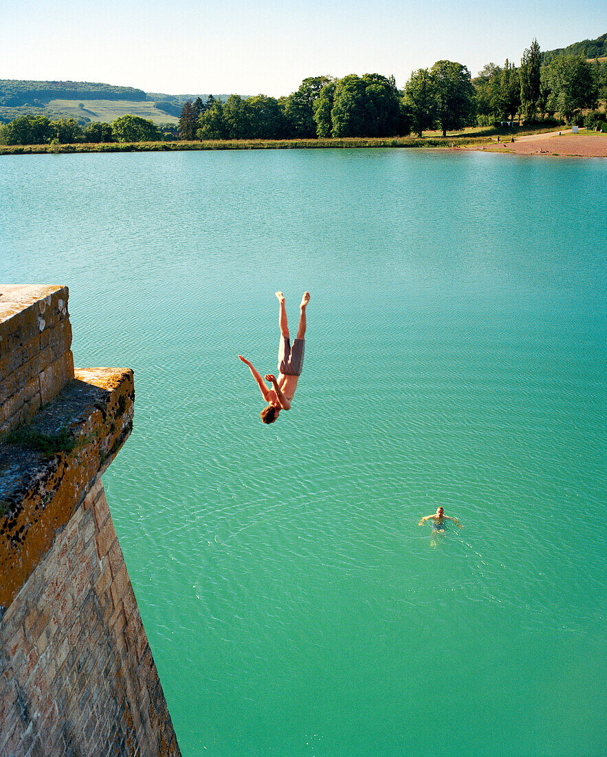 FRANCE, Burgundy, man doing backflip into reservoir, Aubigny Les Sombrenon