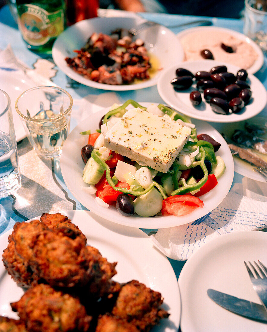 GREECE, Patmos, Diakofti, Dodecanese Island, a table of food including olives and a Greek salad at the Diakofti Taverna