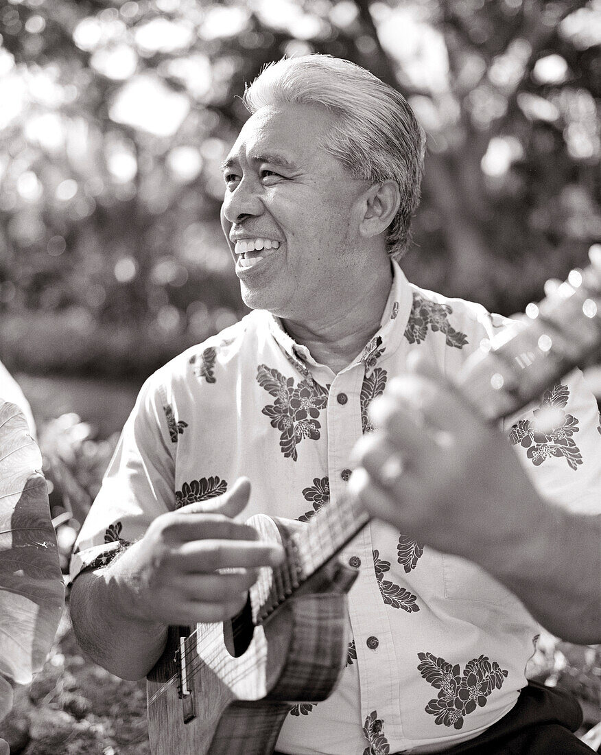 USA, Hawaii, smiling senior man playing ukulele, Four Seasons, The Big Island