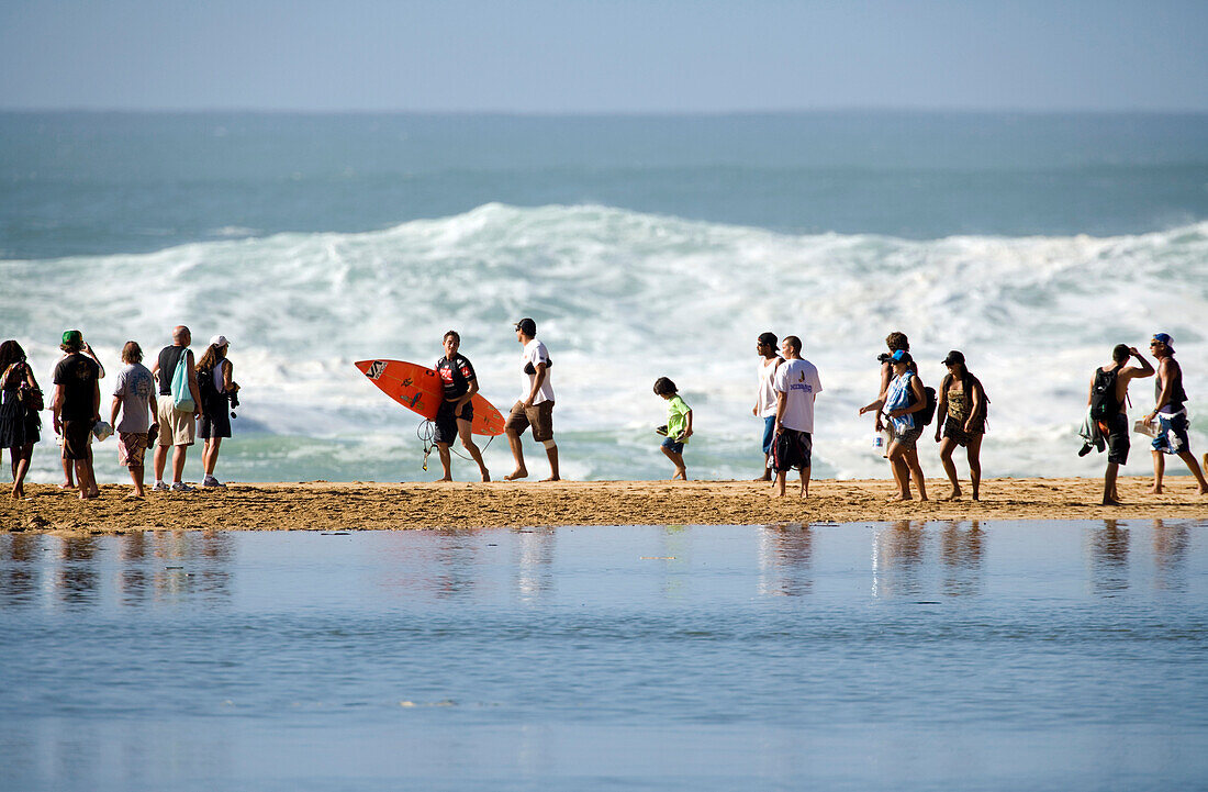 USA, Hawaii, Oahu, a surfer and spectators on the beach at Waimea, Bay