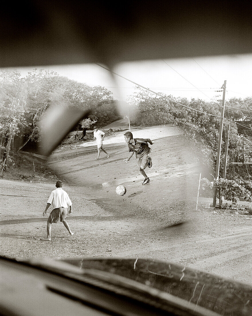 HONDURAS, Roatan, young teenagers playing soccer game (B&W)