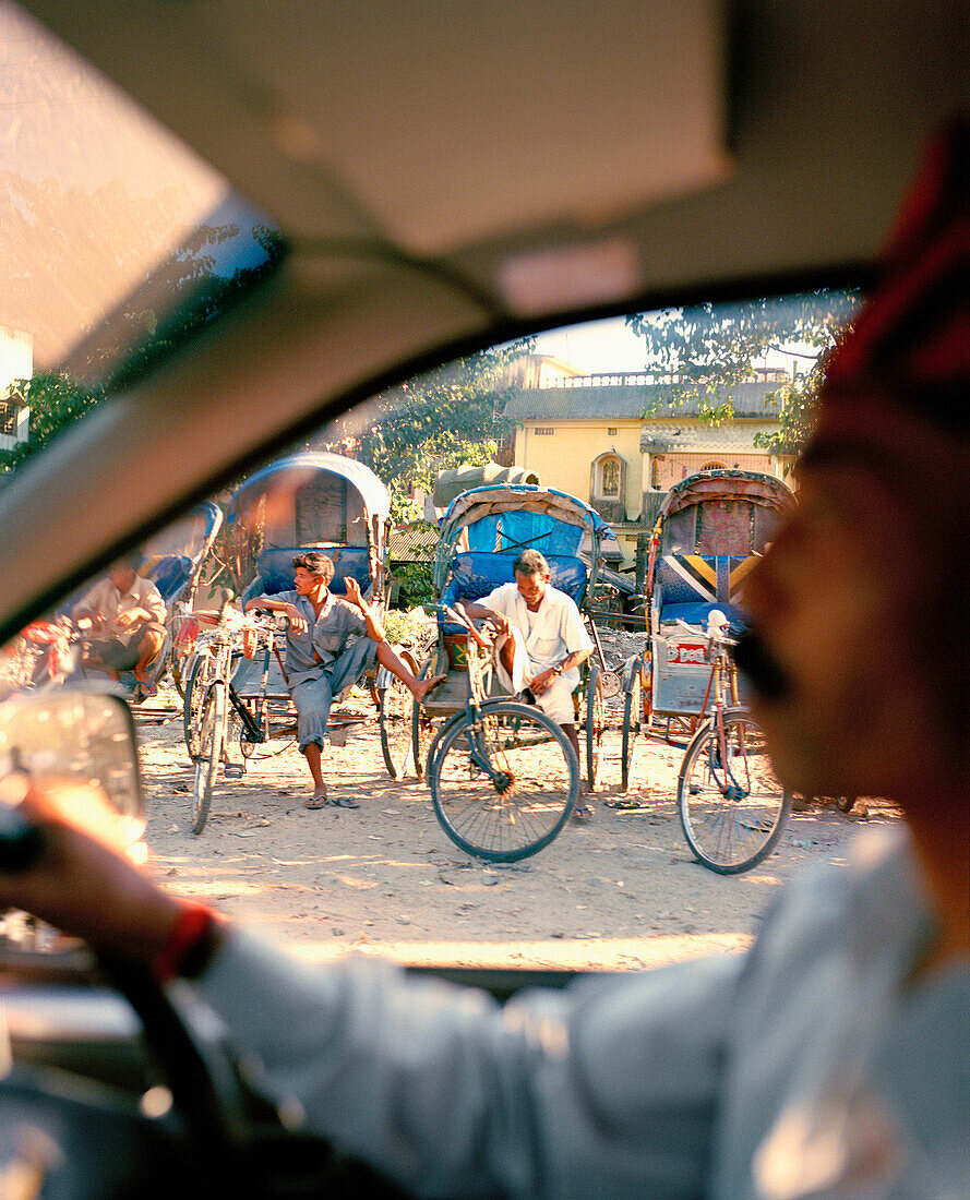INDIA, West Bengal, close-up of taxi driver and bike taxi's, Bagdogra