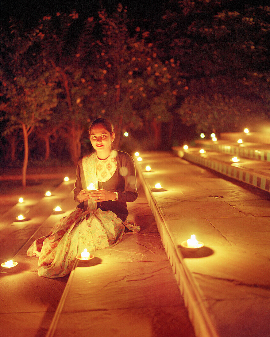 INDIA, Jaipur, woman sitting with lit candles on steps, Oberoi Rajvilas Hotel