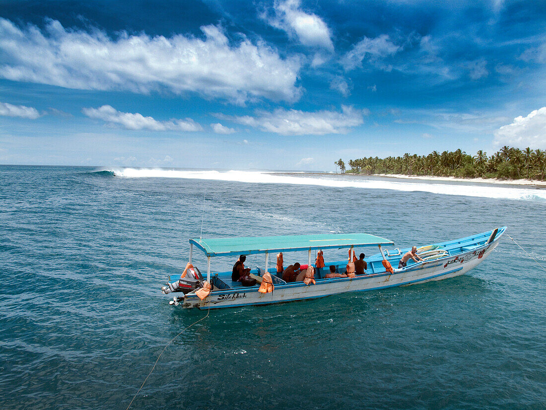 INDONESIA, Mentawai Islands, surf boat anchored at a wave called Bankvaults