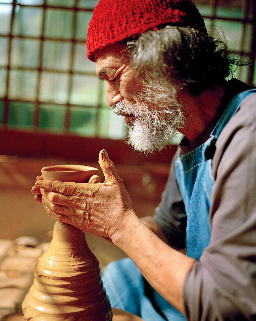 JAPAN, Kyushu, master potter Takashi Nakazawa throwing a tea cup