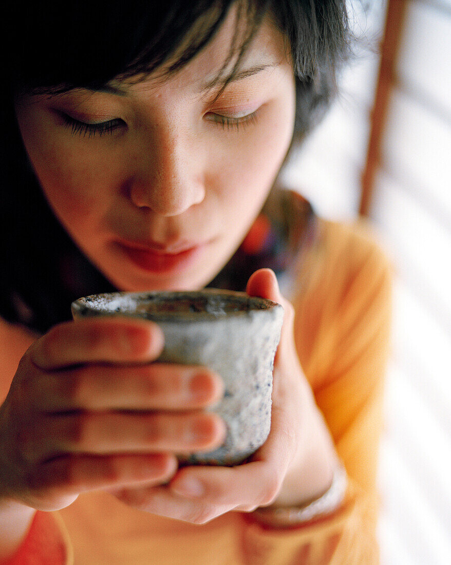 JAPAN, Kyushu, close-up of a young woman a holding teacup