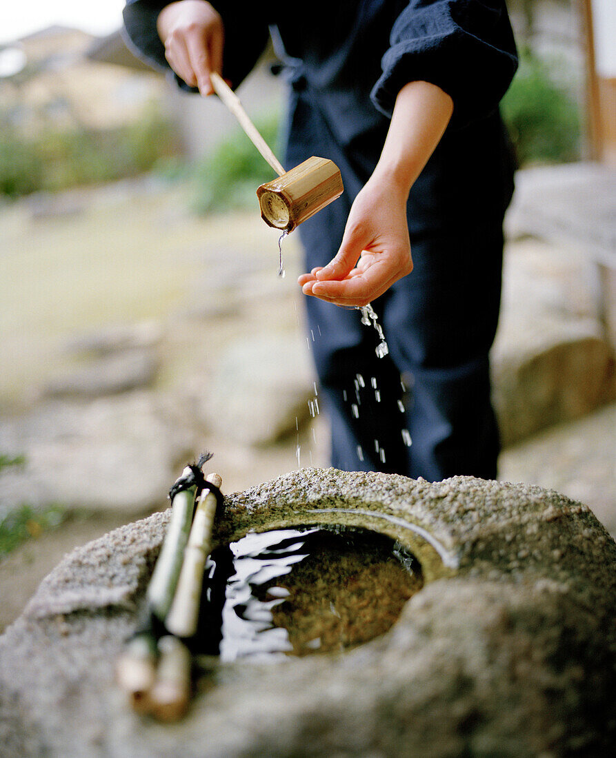 JAPAN, Kyushu, woman washing her hands at the Yoyokaku Ryokan