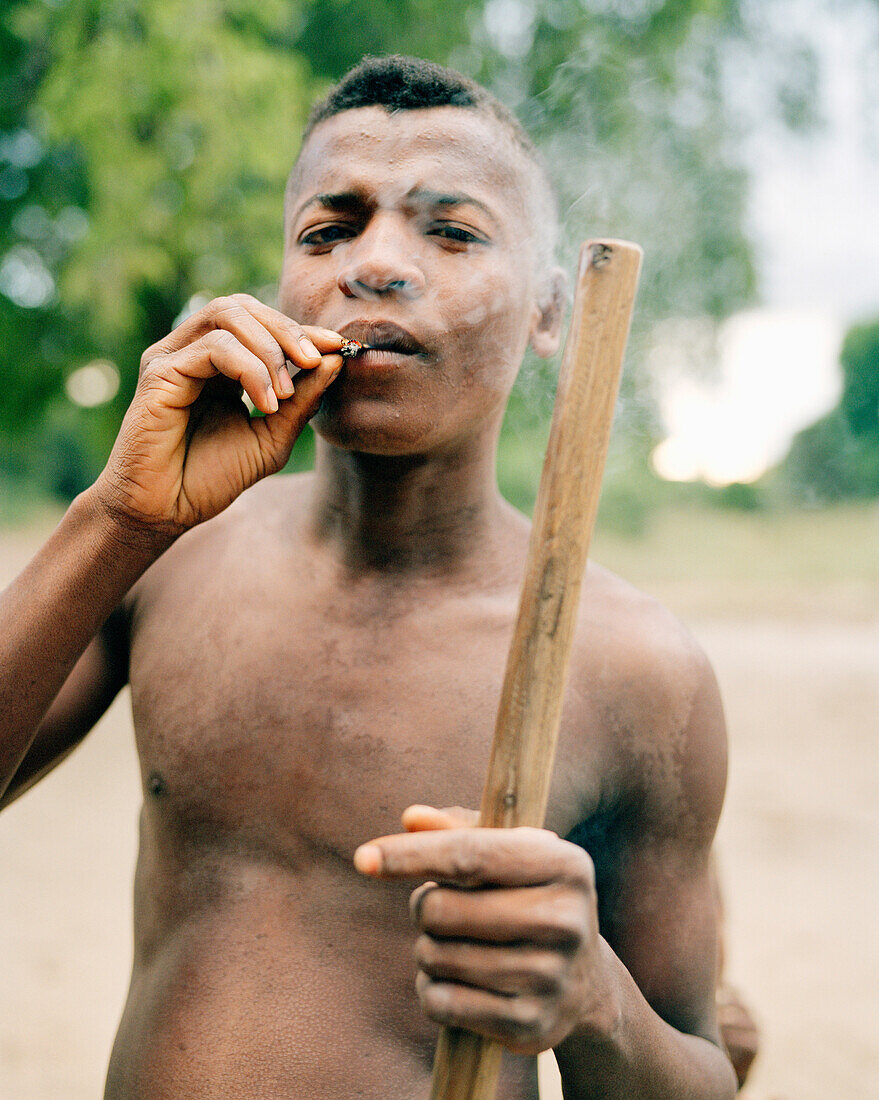 MADAGASCAR, shirtless young man smoking, village of Beza Mahafaly