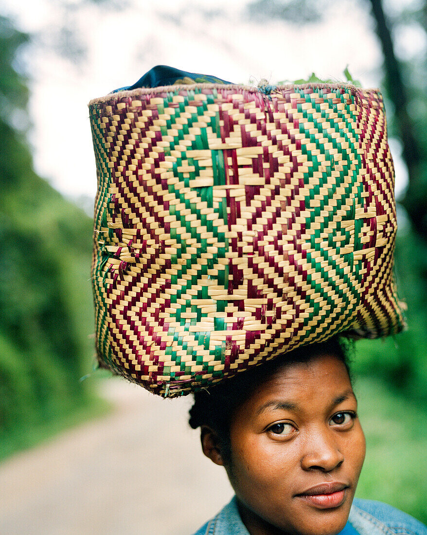 MADAGASCAR, mid adult woman carrying basket on head, Betsimisaraka Tribe