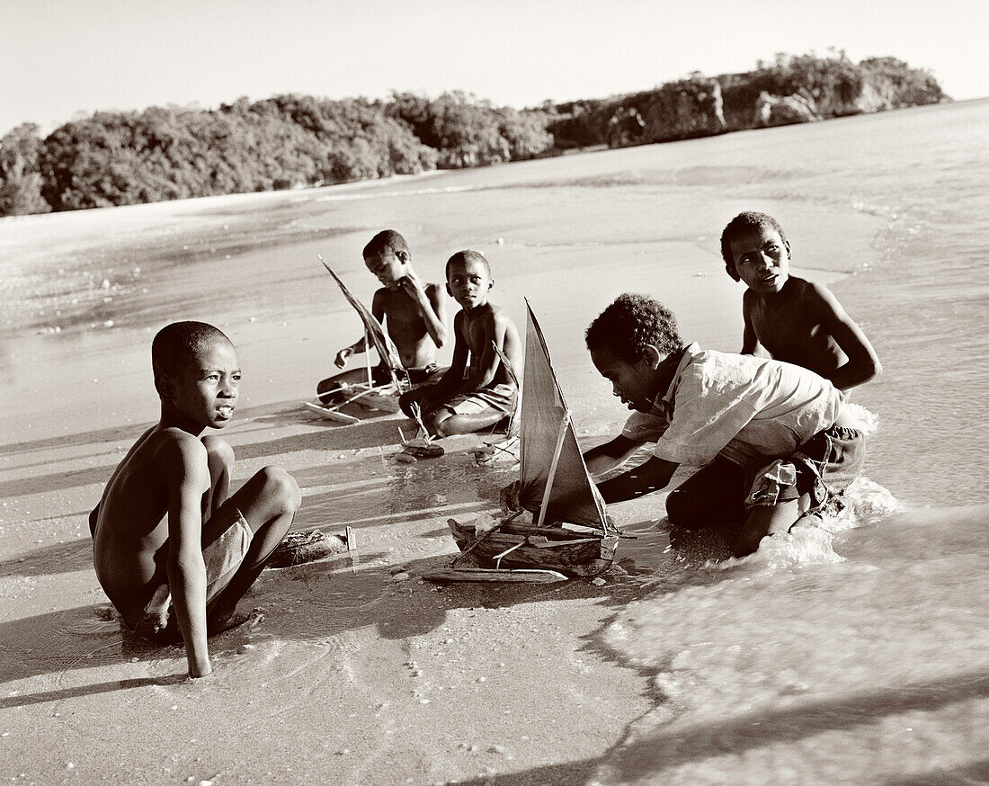 MADAGASCAR, boys playing with toy boats, Anjajavy (B&W)