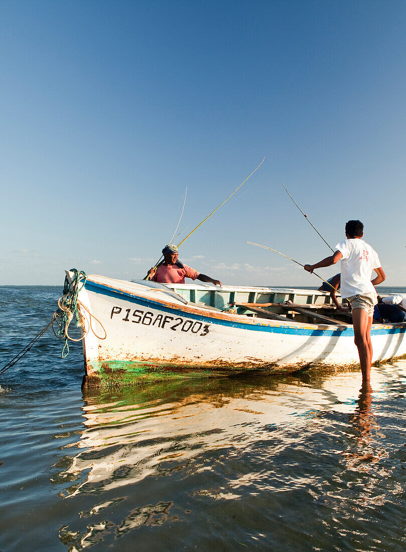 MAURITIUS, fishermen pull their rods out of a boat after a day of fishing, Bel Ombre, Indian Ocean