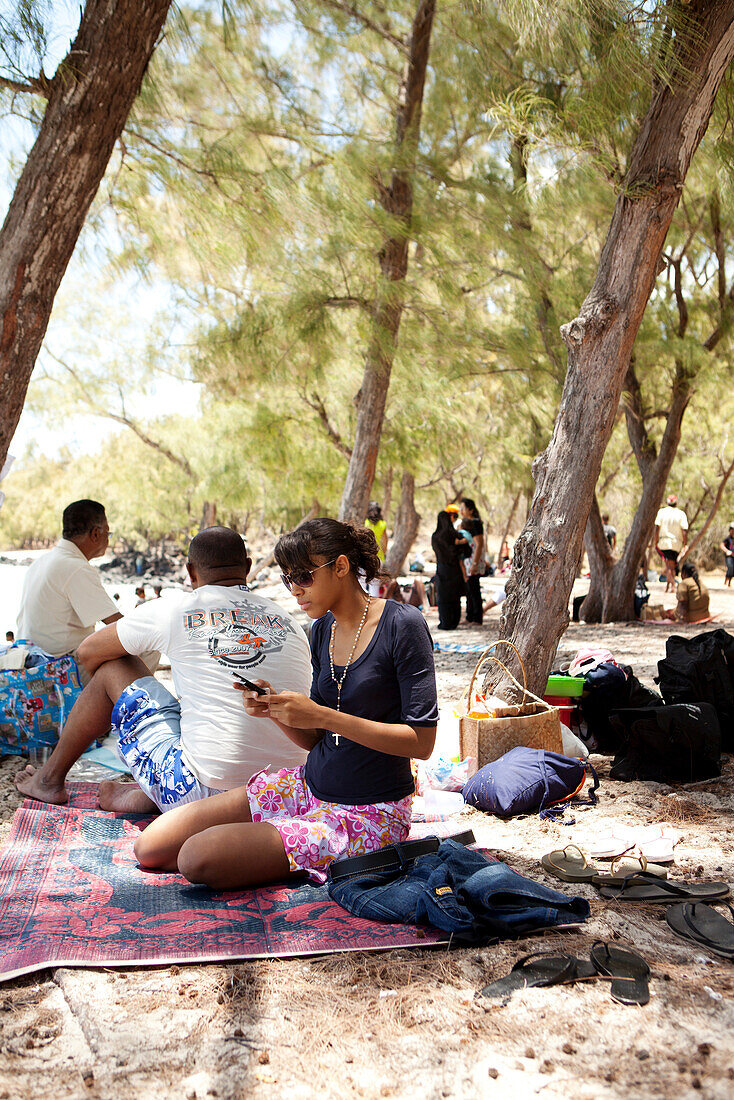 MAURITIUS, friends are enjoy some shade and a picnic on the beach at Ile Aux Cerfs Island