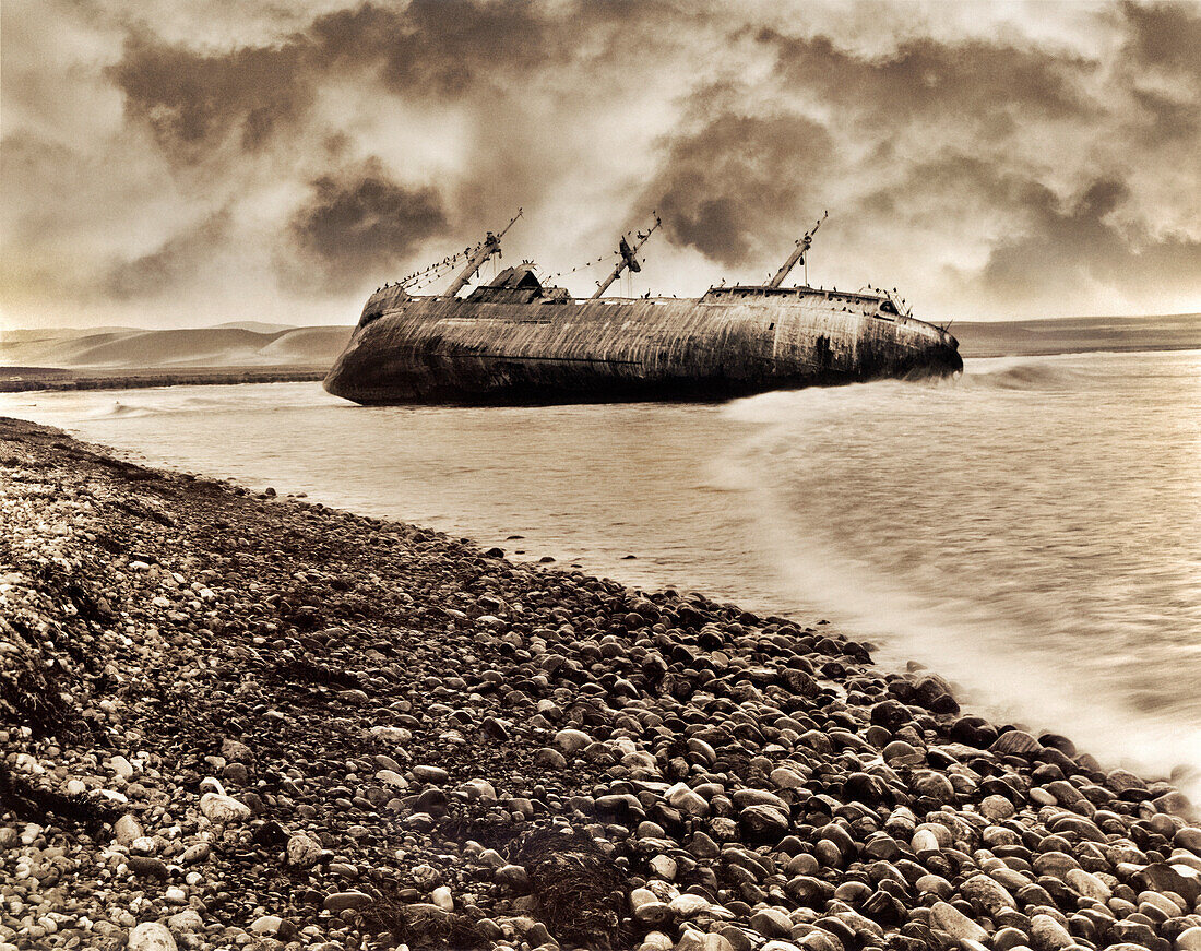 MEXICO, Baja, shipwrecked boat with dramatic clouds, San Quintin (B&W)