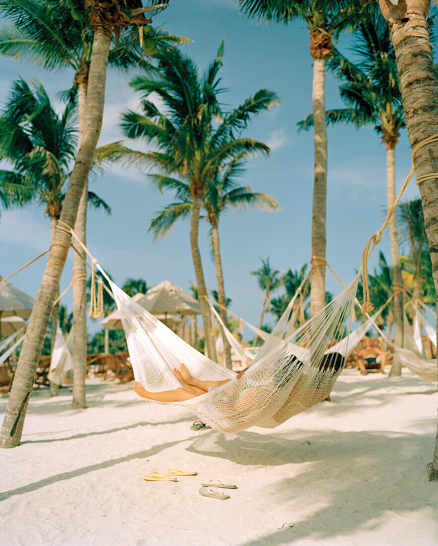 MEXICO, Maya Riviera, couple in a hammock relaxing, Xcaret