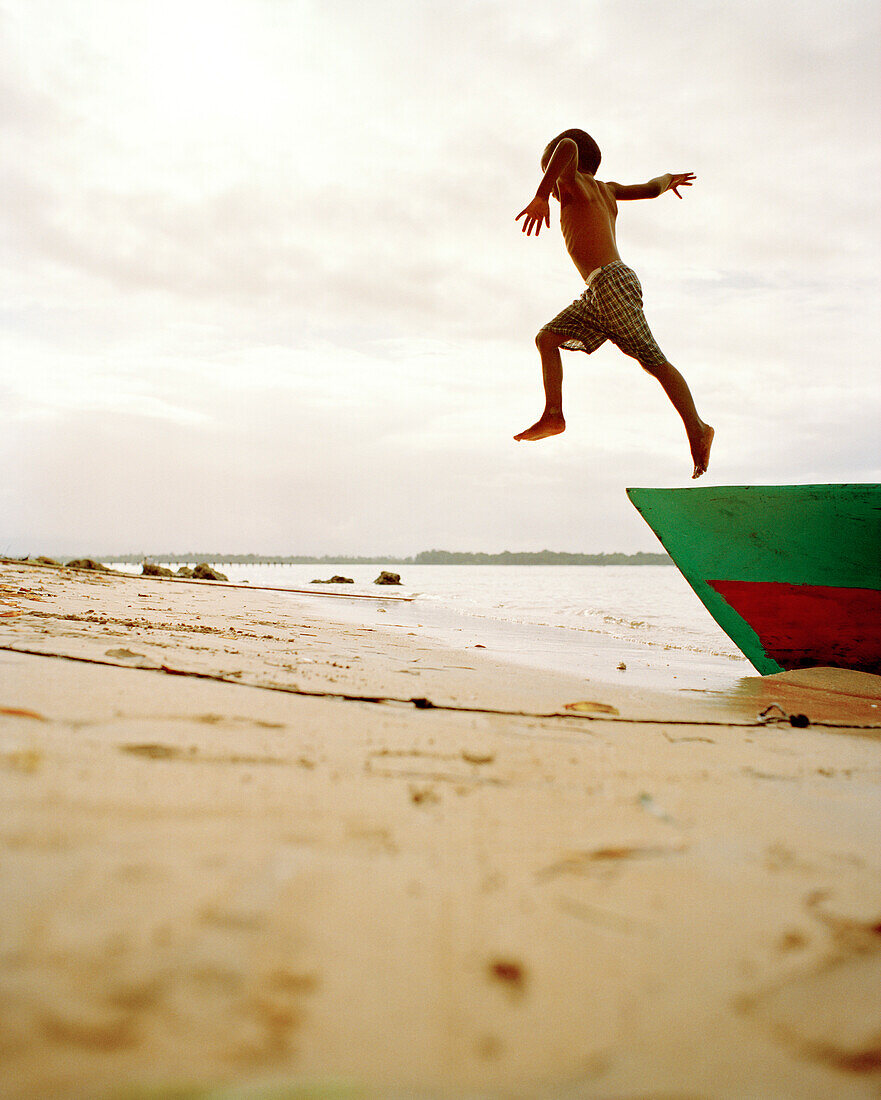 PANAMA, boy jumping off boat onto the beach, Bocas Del Toro