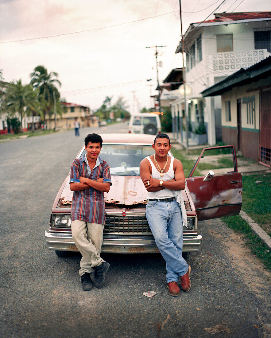 PANAMA, PANAMA, Bocas del Toro, young men rest against their car on Main Street, Central America