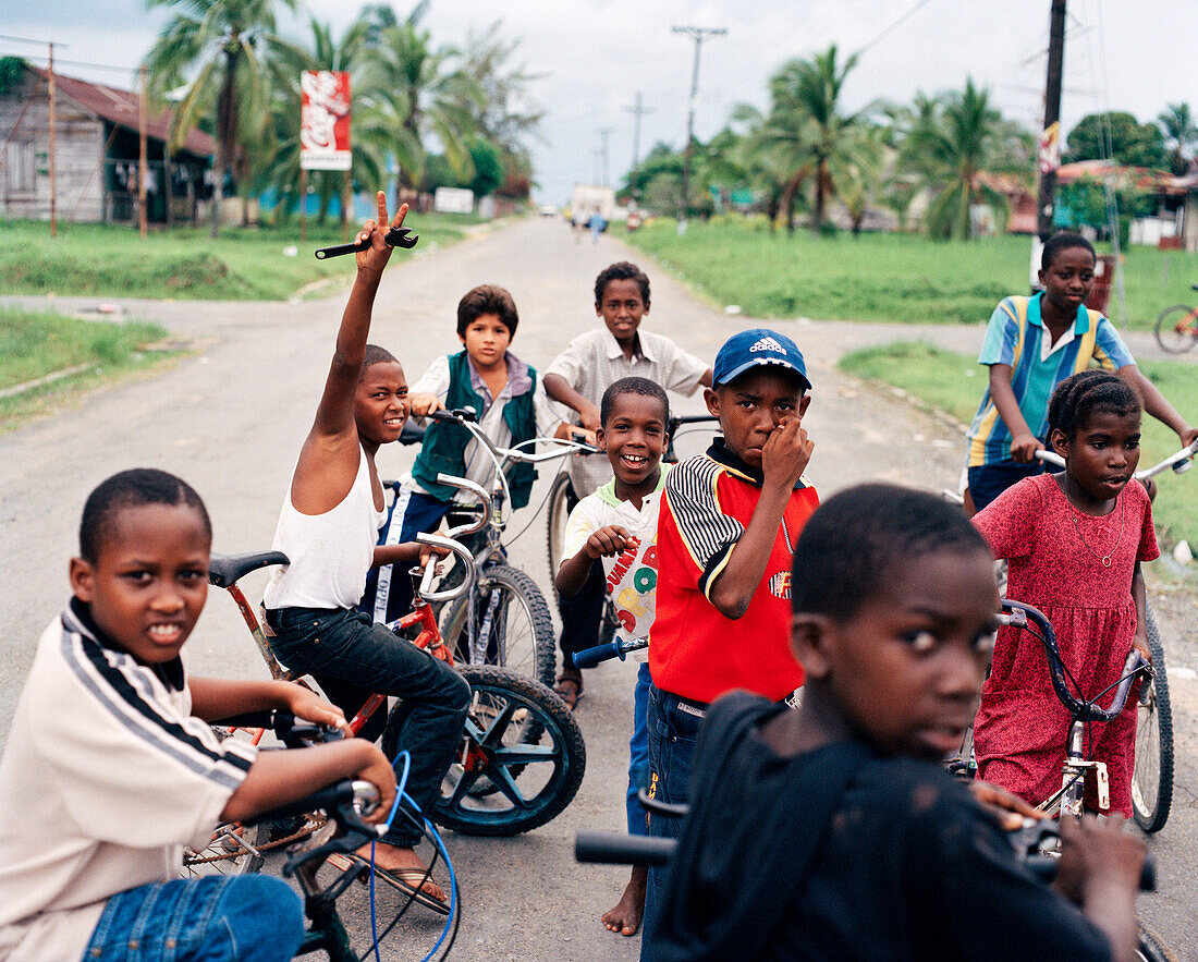 PANAMA, Bocas del Toro, kids on bikes hang in the street and wait to get access to the airport runway, Central America