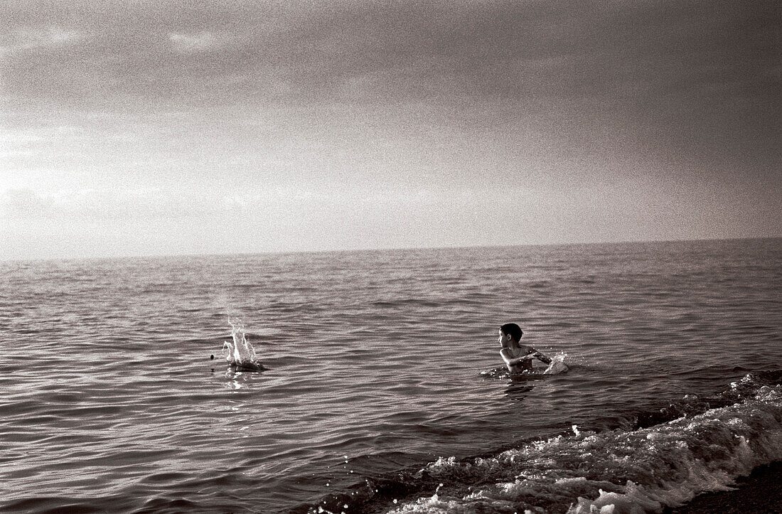 REPUBLIC OF GEORGIA, boy skipping a stone in the Black Sea, Batumi (B&W)