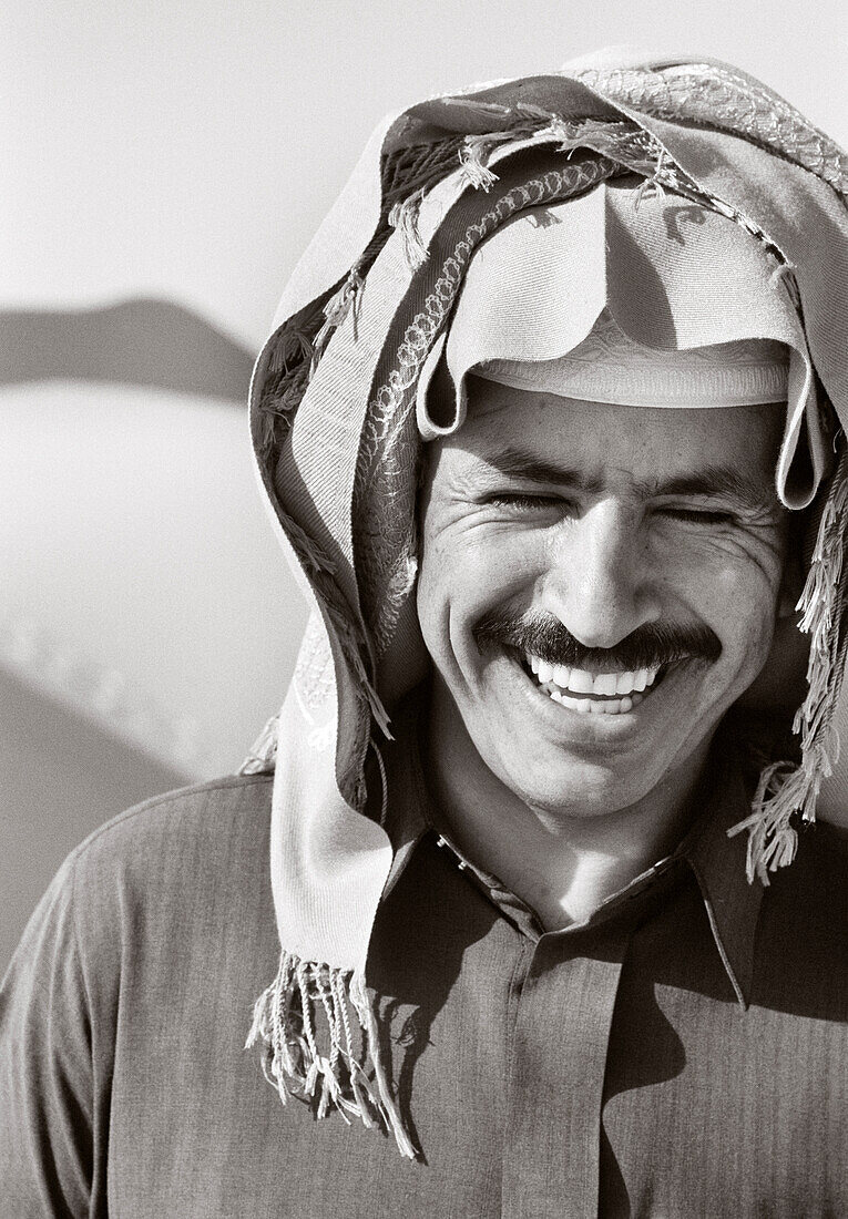 SAUDI ARABIA, smiling Egyptian Bedouin man in traditional clothing, The Empty Quarter, Najran (B&W)