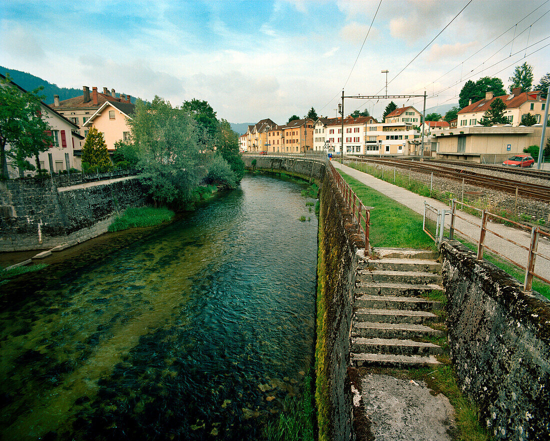 SWITZERLAND, Couvet, L’arerse River running through the center of town, Jura Region