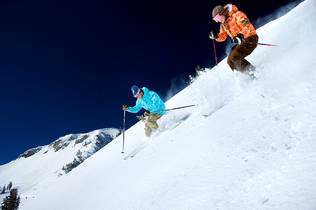 USA, Utah, man and woman skiing together in the Yellow Trail Area, Alta Ski Resort