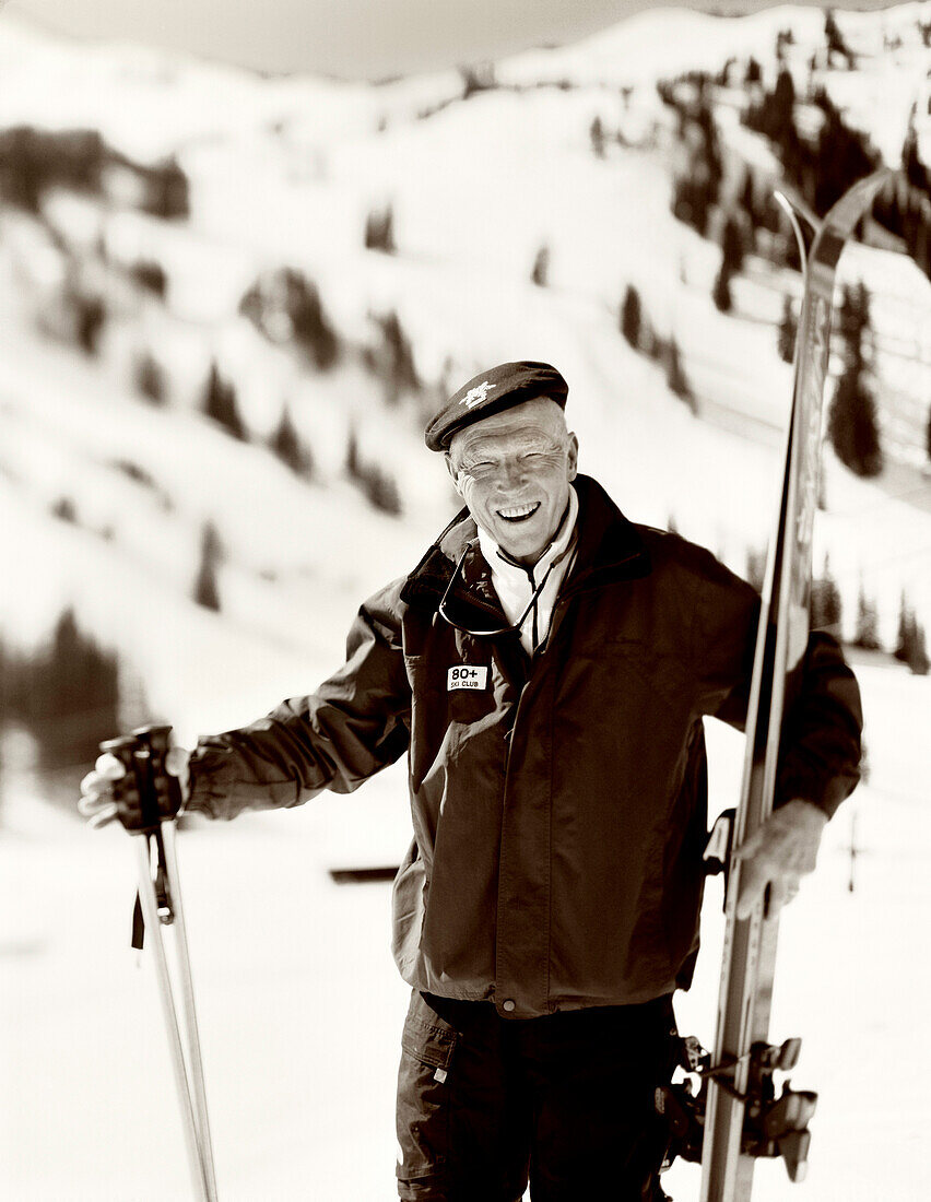 USA, Utah, portrait of a senior man holding skis and ski poles, 80+ ski club, Alta Ski Resort (B&W)