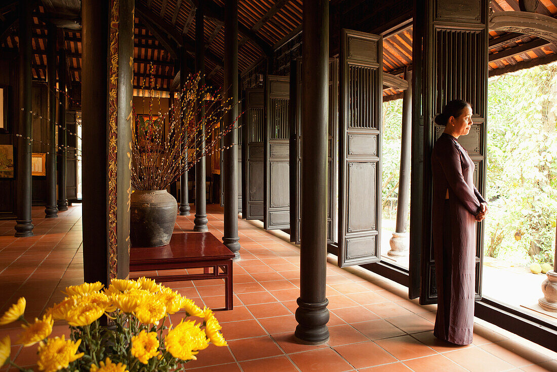 VIETNAM, Hue, Ms. Boi Tran standing in a beautiful room in her home where she displays her paintings