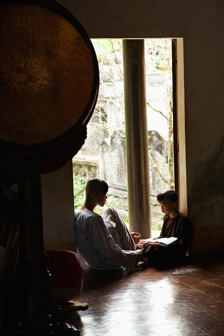 VIETNAM, Hue, a monk studies with a young student at the historic Tu Hieu pagoda and monastery