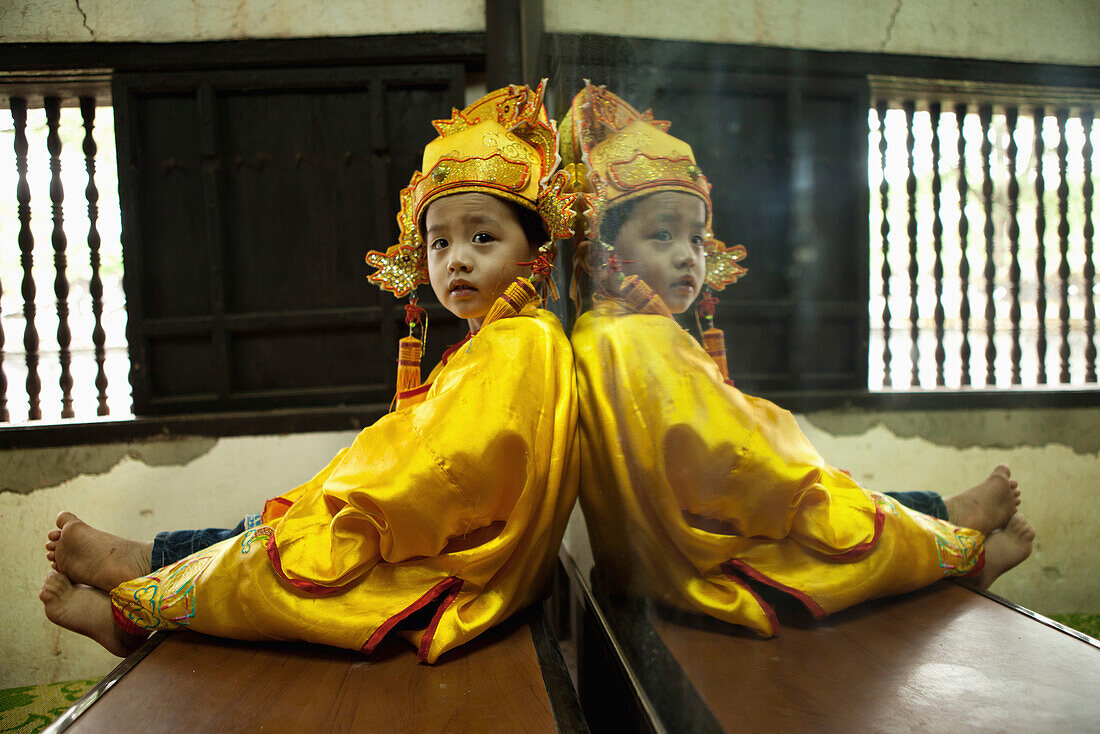 VIETNAM, Hue, Tu Duc Tomb, a young dancer is dressed in traditional Vietnamese costume and waits to perform with his mother
