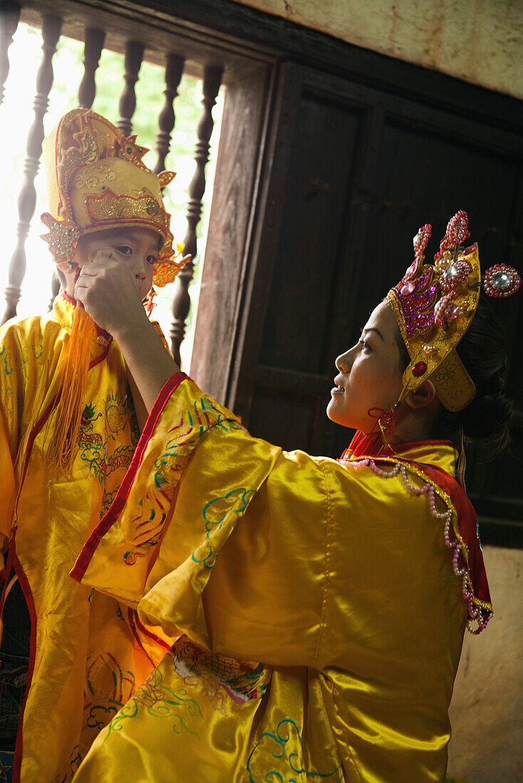 VIETNAM, Hue, Tu Duc Tomb, dancer Ms. Nguyen Ngoc Thien and her son dress in traditional Vietnamese costume and prepare for a performance