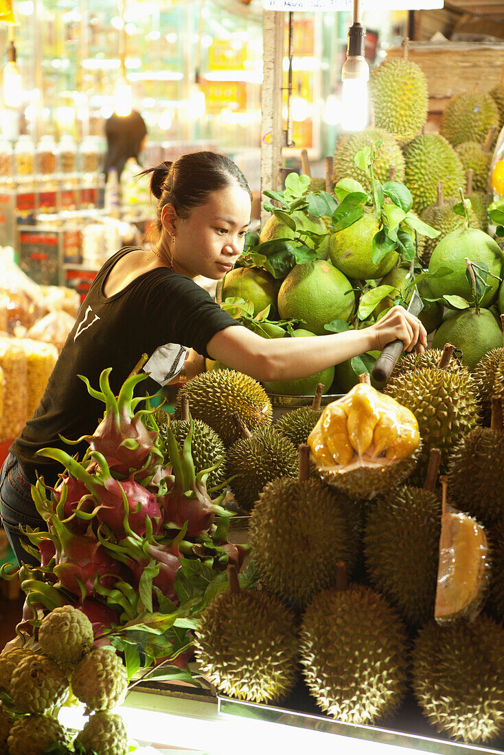 VIETNAM, Saigon, Ben Thanh Market, a vendor arranges the Duran or Kho Qua Xanh, one is split open showing the fruit inside, Ho Chi Minh City