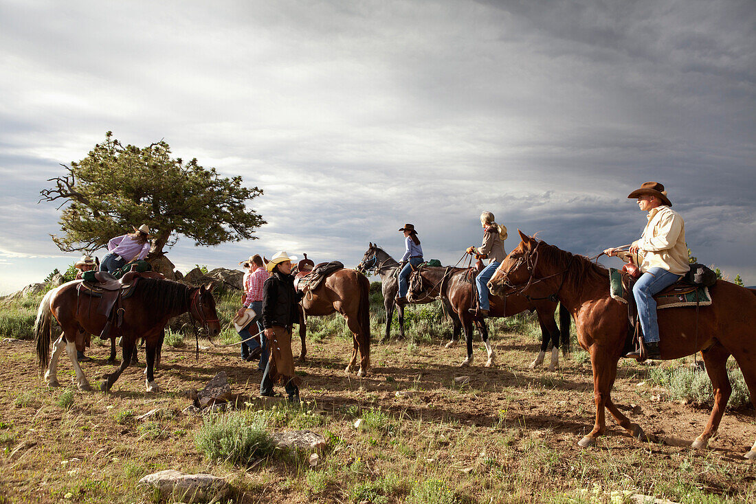 USA, Wyoming, Encampment, wranglers take horses from guests after a ride, Abara Ranch