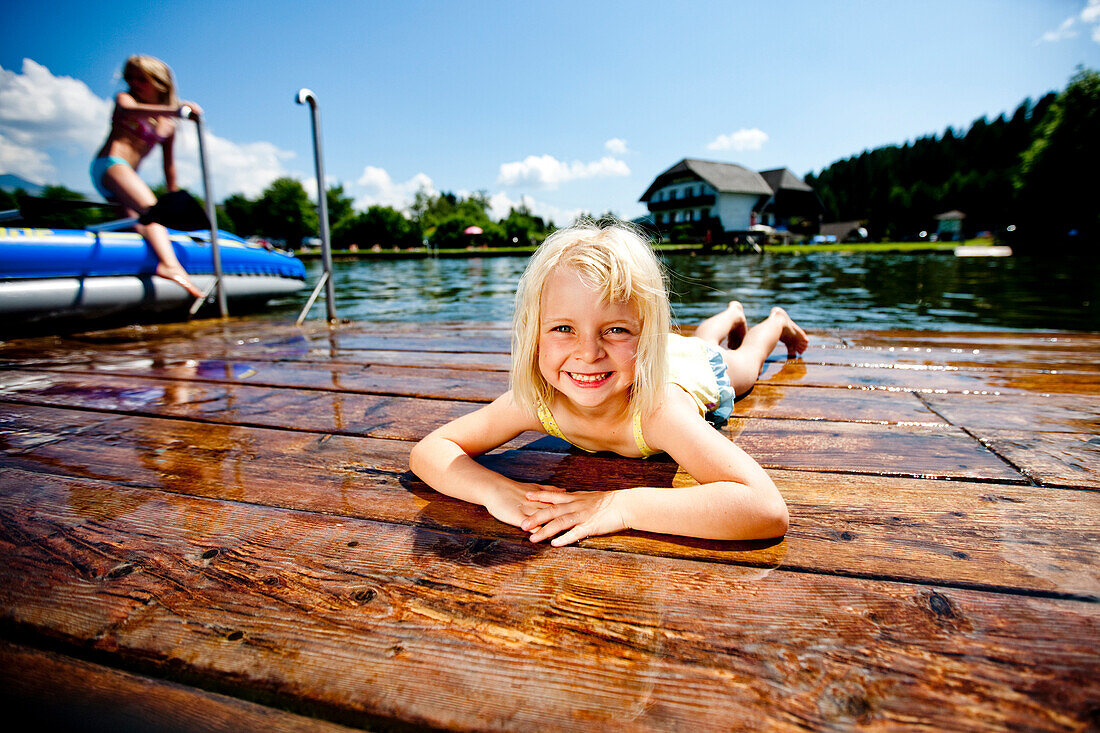 Mädchen liegt auf einem Steg am Furtner Teich, Mariahof, Murtal, Steiermark, Österreich