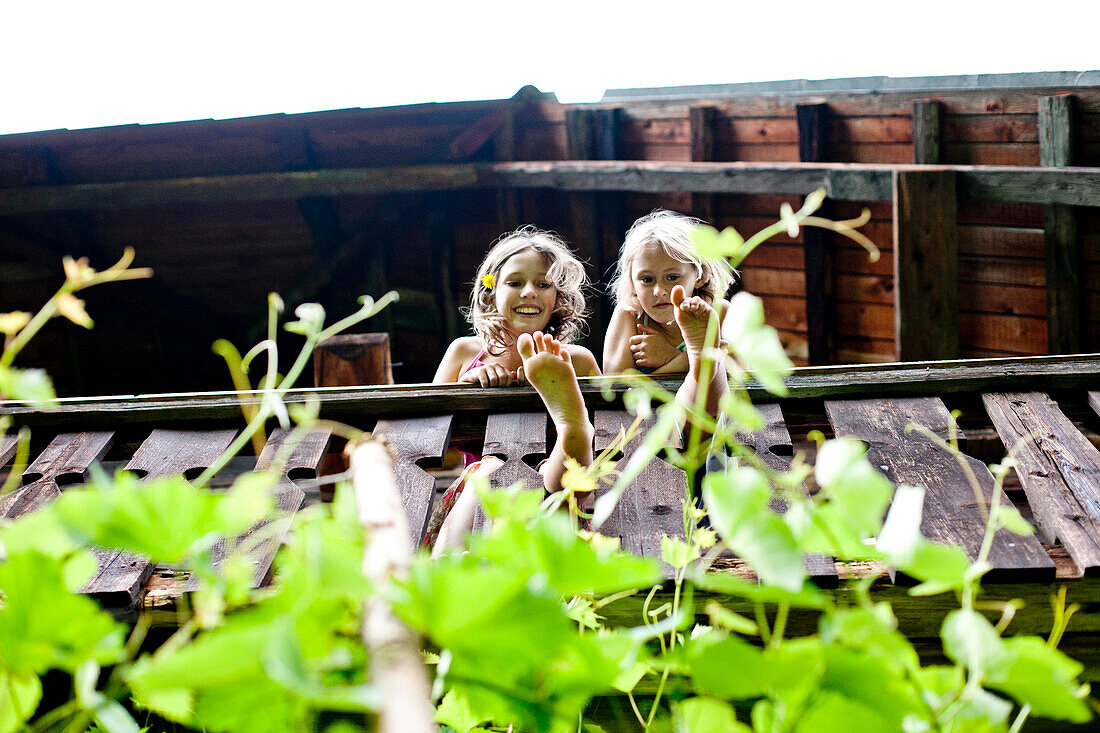 Zwei Mädchen stehen auf einem Balkon, Steiermark, Österreich