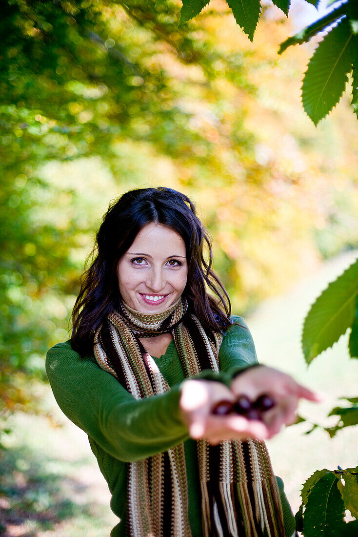 Junge Frau hält Kastanien in den Händen, Steiermark, Österreich