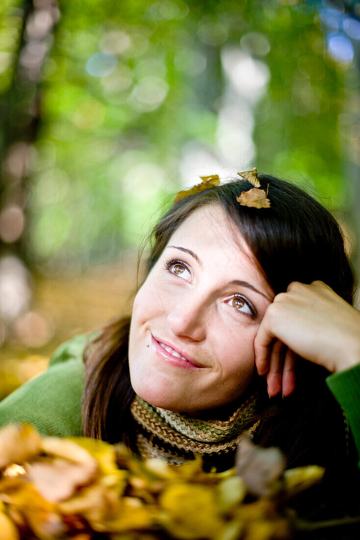 Young woman between autumn leaves, Styria, Austria